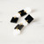 Earrings consisting of 2 rows of 4 alternating black squares and white squares and black circles and white circles linked by small gold jump rings with post for ears on top shape.