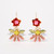 Pair of colorful beaded dangle style earrings featuring glass and resin beads with red flowers above a semi-circle of oblong gemstones of pink and light green with gold ear wires