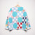 Back of Primarily turquoise blue patched quilted jacket with snap closure on hanger