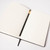 Detail of open notebook with white pages and black Black Wing pencil laying on top