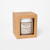 Brown craft paper box with open front panel with Lavender Clouds Candle by Mount Airy Candle Co. visible through window