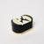 Oval shaped small acrylic box with black sides and removable top of white, black and ivory