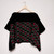 Primarily black top on hanger; top portion solid black with patterned section below featuring horizontal waves of red with white detail