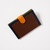 Brown leather passport wallet with dark blue frame border and mustard-tone snap closure