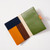 Interior of leather passport wallet with dark blue, brown and mustard on left panel and sage green panel on right side