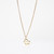 Gold-toned pretzel-shaped pendant hanging from fine gold-toned chain