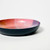 Side view image of the round trinket dish which is dark blue.