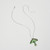 Green luna moth-shaped ceramic pendant laying flat with silver chain shown open