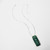 Rectangular ceramic pendant of green with debossed image of thistle plant suspended on silver chain shown unclasped
