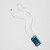 Rectangular blue ceramic pendant featuring embossed magnolia flowers on silver chain shown unclasped