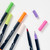Close-up view of the markers with a couple of caps removed to show both the fine-point and brush tip on either end of each marker.