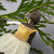 Image features a close-up of the face and dress of the Degas Little Dancer ballerina ornament with a branch in the background.