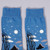 Side detail top view of Rousseau Carnival Socks lying flat. The socks depicts bare trees in black against a nighttime dark blue sky with white moon and stars. Toes and heels are black.