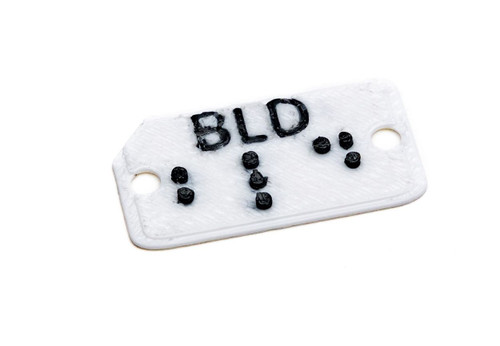 Image: brailled clothing tags, dark blue