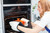 image: silicone guard on a rack; pot coming out of the oven