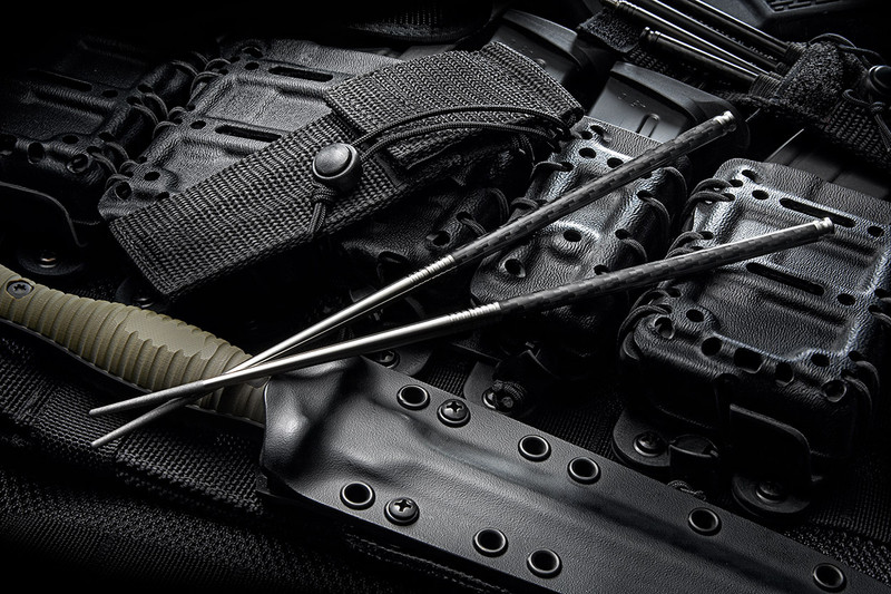 Spartan Blades Titanium Chopsticks with carbon fiber twill handles and textured tips, shown in a rugged nylon carry case for compact everyday carry.