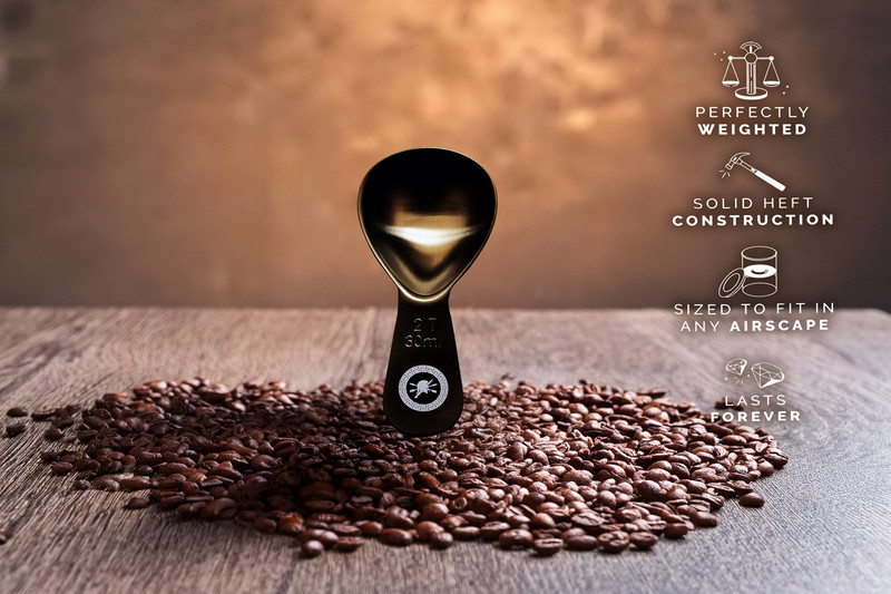 Brushed black stainless steel Spartan Blades coffee scoop with long handle, designed to measure 2 tablespoons of coffee.