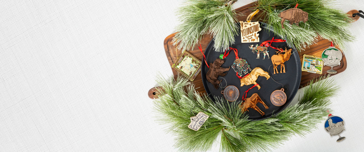 Yellowstone National Park ornaments surrounded by pine boughs on a linen background