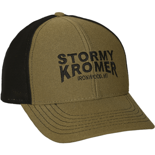 45 degree angle view of The Performance Trucker Cap: A traditional baseball style cap with the front two panels and brim in a muted olive color, and the back in black mesh. Featuring the words Stormy Kromer embroidered on the front.