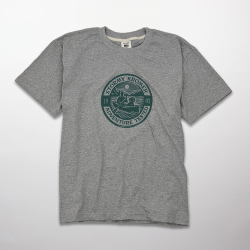 A sport gray short sleeve tee with a printed graphic of a man in a canoe with a dog in a circle stamp.