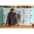 Bearded man in his 40s standing in a bright kitchen, with a red coffee mug. Man is wearing a dark Stormy Kromer cap, a blue, gray and brown plaid flannel shirt and a gray waxed cotton vest.