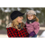 A lady holding a little girl wearing a Lil' Petal Pusher outside in the winter.