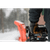 Person using a snowblower outside in the winter