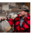 A man wearing a red/black wool Mackinaw coat and a brown waxed cotton cap with his arm around a tan, short-haired dog wearing a red/black plaid pet bandana