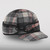 A 45 degree angle view of The Sidekick Cap: a wool, six-panel winter cap with a pulldown earband that ties off to the side, and a brim.