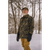 Gray bearded man wearing a waxed camo Squall Coat outside in the snow.