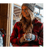 Lady wearing a red/black plaid jacket and beanie holding a coffee cup.