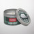 Tin jar candle from Kalamazoo Candle with a green plaid lid and band with Stormy Kromer logo