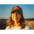 A smiling lady wearing the olive colored Logo Trucker Cap at the lakeshore.