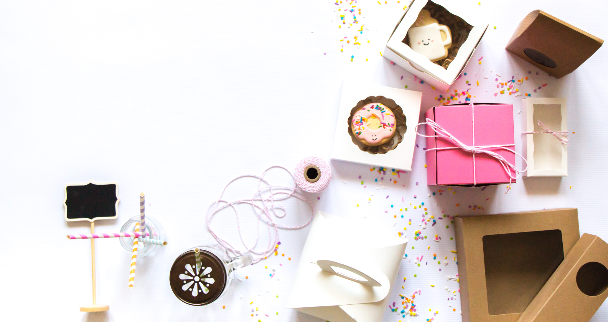 Bakery packaging with pink boxes, treats, and ribbons