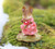 A Wee Forest Folk miniature figurine of a sweet mouse in a pink dress with heart motifs, holding a pink daisy and plucking the petals to guess whether he loves me, or loves me not.