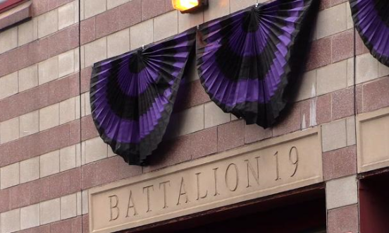 Purple and black funeral buntings displayed on a fire station