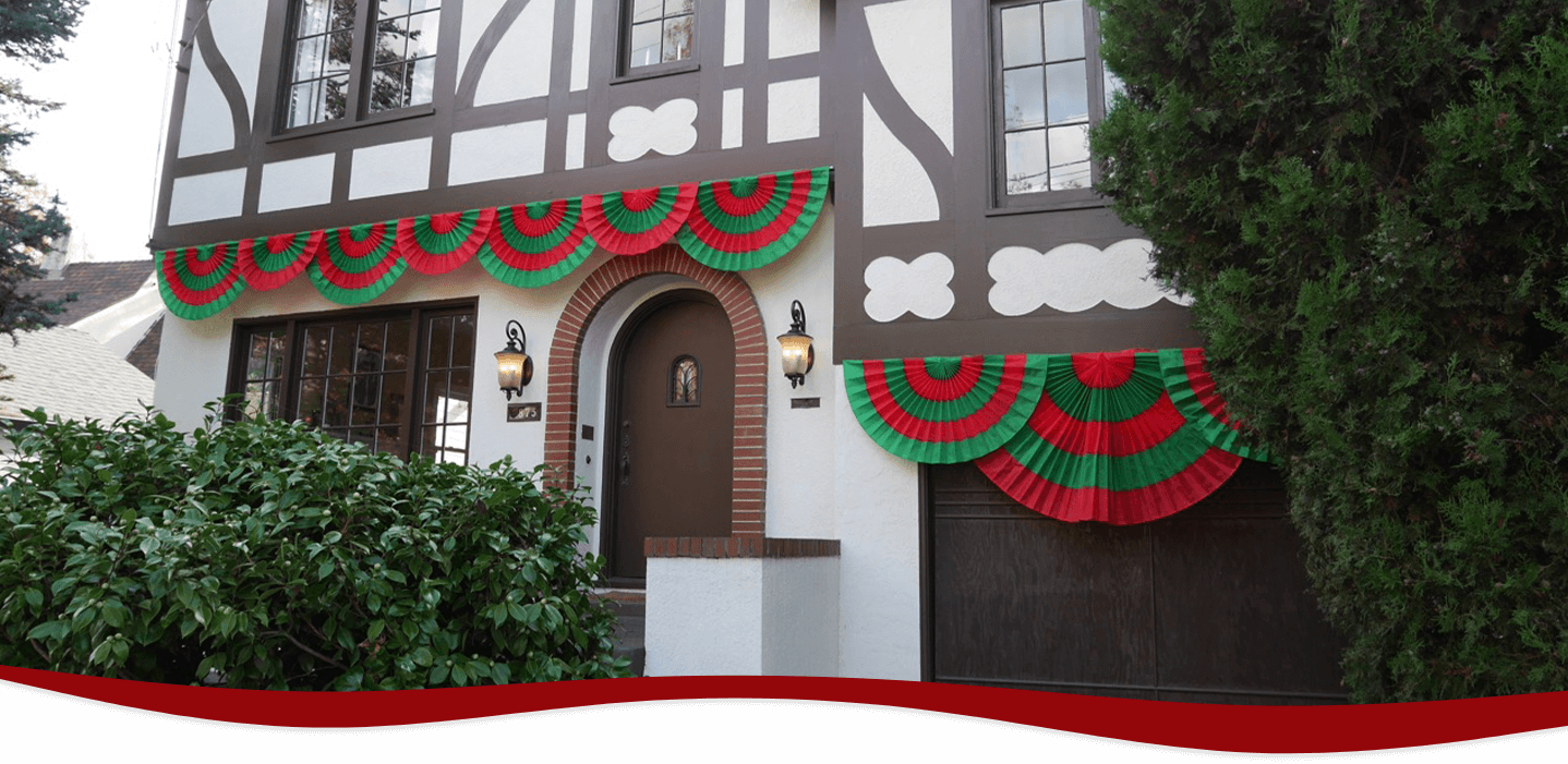 Red and green Christmas bunting fans displayed on a house