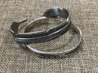 Two silver feather cuff bracelets