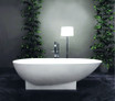 Freestanding Pure Series bathtub with modern design, solid stone-like material, surrounded by greenery and a floor lamp