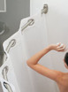 Curved shower rod in a bathroom setting with a person reaching for a shower curtain