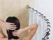 Woman adjusting her hair in front of a curved shower rod with a shower curtain