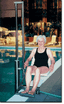 Woman using an Aquatic Access IGAT-180 pool lift at a swimming pool