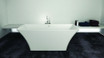 Stand-alone bathtub from the Pure Series, with a modern design, sleek white finish, and contemporary faucet