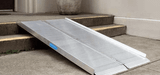Folding aluminum curb ramp positioned against stairs