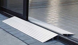 Aluminum threshold ramp positioned at a doorway, designed for accessibility