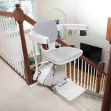 Modern Bruno Elan SRE-5000 straight stairlift mounted on a home staircase, engineered for accessibility, aging in place, and increased independence with a quiet ride and space-saving design.