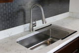 Luxe stainless pull-down kitchen faucet installed over a stainless steel sink with marble countertop