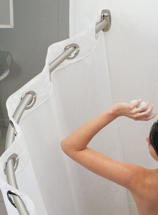 Curved shower curtain rod installed in a bathroom, with a person reaching out while showering