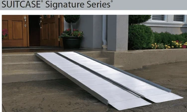 Aluminum SUITCASE Signature Series ramp positioned at a doorway, facilitating wheelchair or scooter access