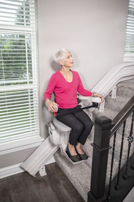 Senior woman using a Bruno stair lift on a staircase